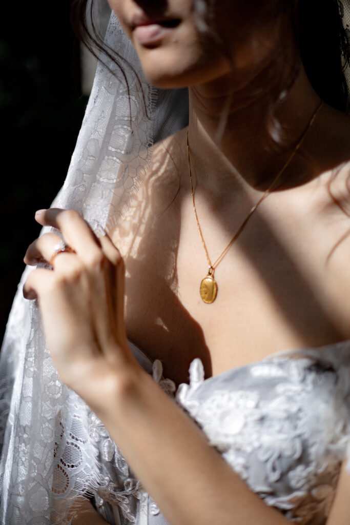 Bride showcasing her beautiful Marian medal glowing in gorgeous sunshine.