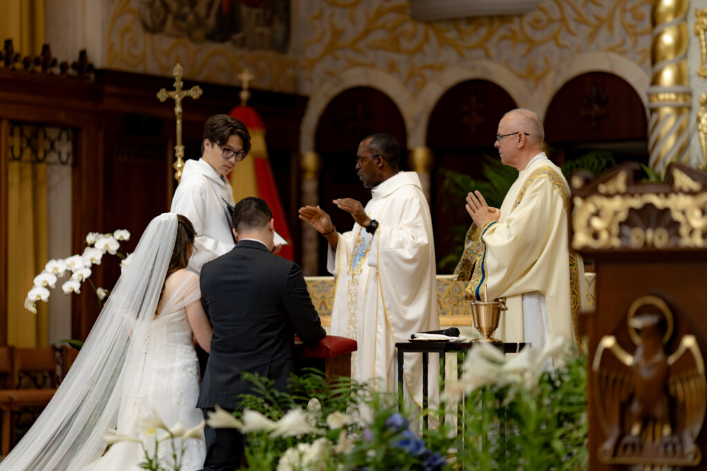 Priest gives the nuptial blessing during the Florida Catholic Wedding. 