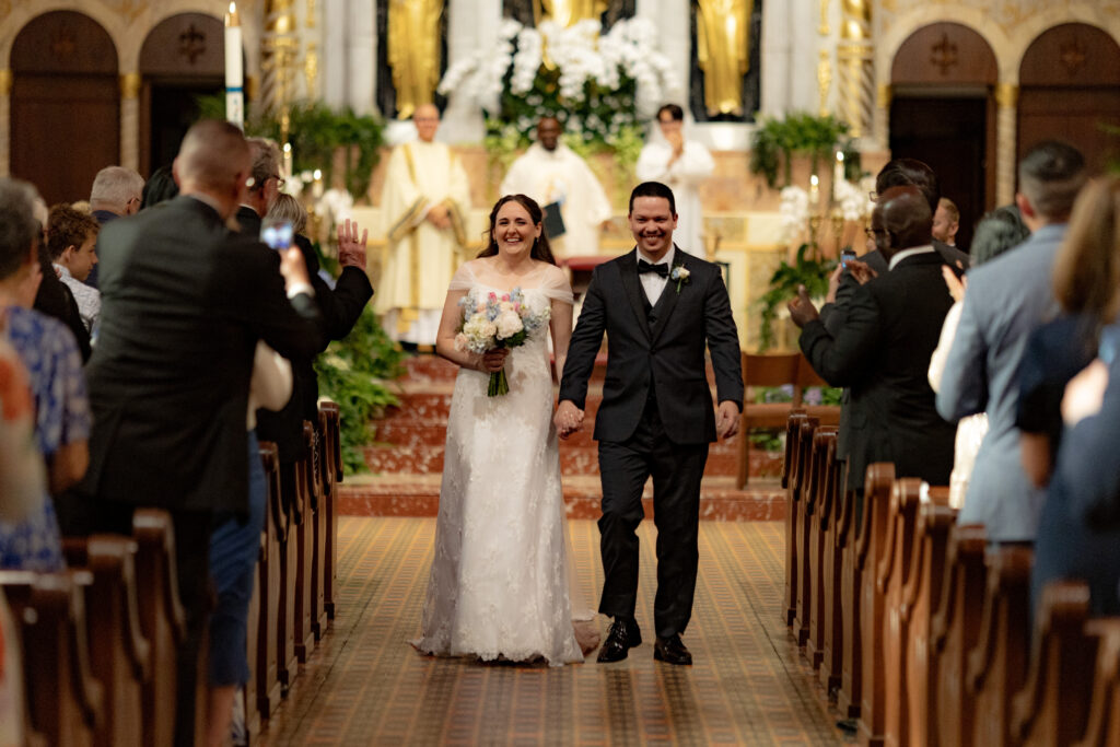 Bride and Groom joyfully recess down the aisle after their wedding mass at the Cathedral Basilica of St. Augustine Florida.