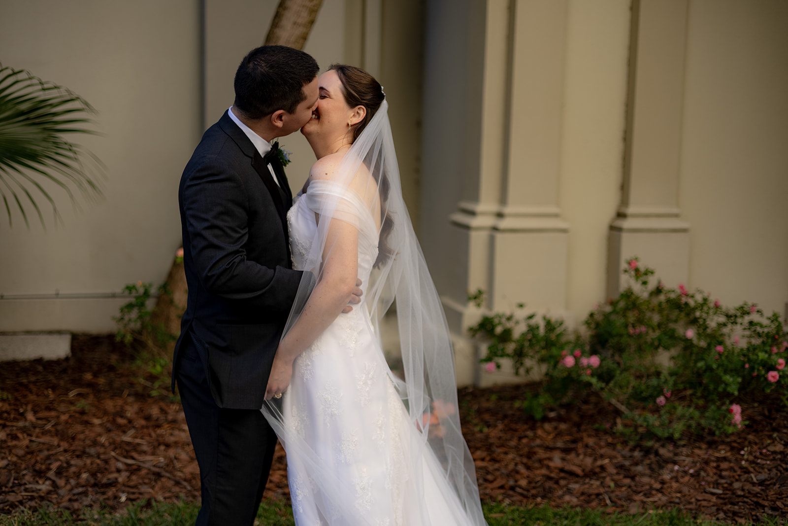 Bride and Groom kiss romantically in the Florida sunshine just after their Catholic Wedding Mass.