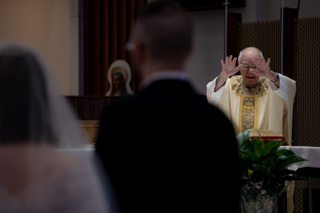 Priest gives the nuptial blessing to a Catholic Couple during their Catholic Wedding Mass in Cleveland, OH.