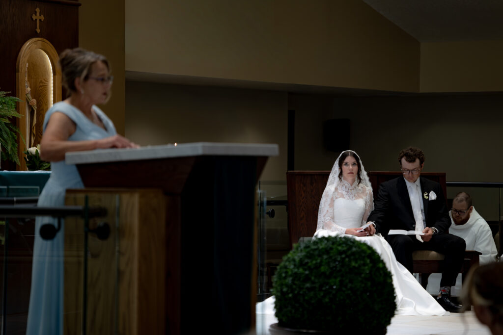 Catholic Couple looks on as the Groom's mother reads the First Reading during the Toledo Catholic Wedding Mass. 
