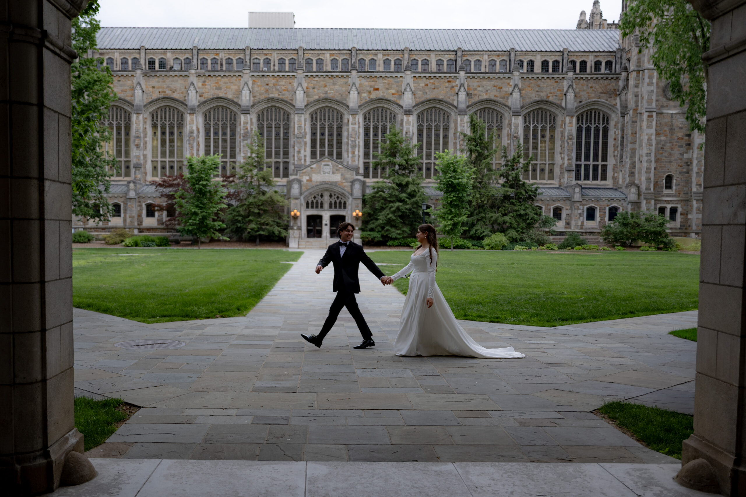 bride and groom walk across the university of michigan's law quad